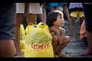 Donna-Grace Orbong, 5, sits with her family's food bag following a distribution by the United Methodist Committee on Relief for survivors of Typhoon Haiyan in Tacloban, Philippines.