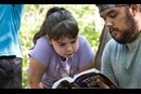 Camper Klaira Hargrove studies the Bible with counselor Emilio Almendarez during morning worship at Cedar Crest Camp in Lyles, Tennessee.