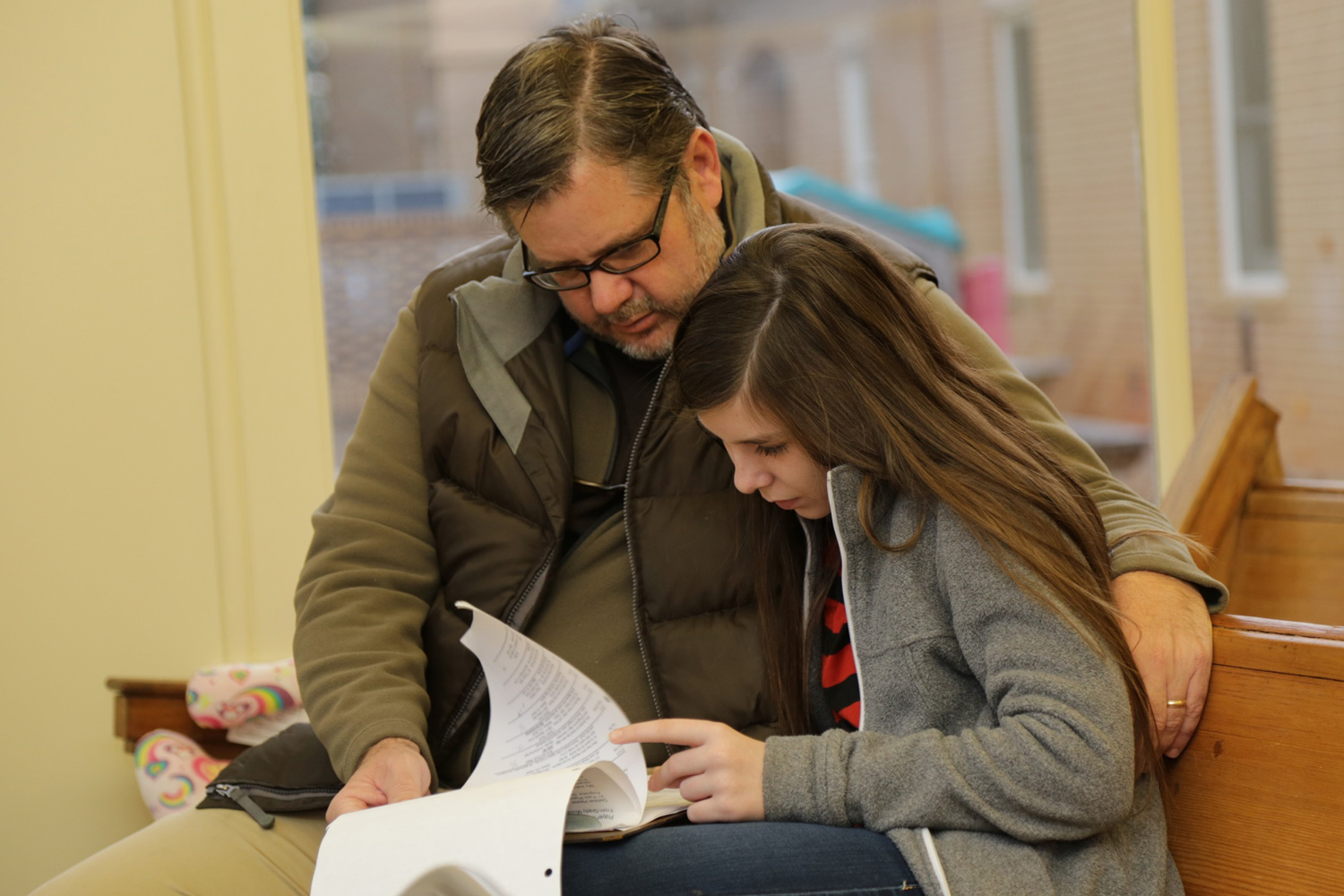 A father and daughter share time together while serving a prayer ministry. 