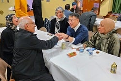 The Rev. Mark Salvacion (right center), pastor of St. Luke United Methodist Church in Bryn Mawr, Pa., holds the hands of Ahmad Abdel-Hamid, president of As-Salaam Islamic Society As-Salaam Islamic Society, after a fellowship feast March 15 at the church, during the holy month of Ramadan. Looking on are Abdel-Hamid’s wife, Nevan Hamid (left), AIS leader Gail Montgomery Watson (right) and a non-Muslim visitor, Desiree Bright-Threadgill. Photo by John W. Coleman, UM News.