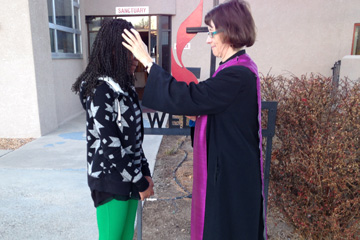 The Rev. Kim Kinsey applies ashes outside of her church building. 
