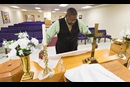The Rev. Mark Windley prepares the altar for worship at Amazing Grace Community of Faith in Louisville, Ky. Photo by Mike DuBose, UMNS.