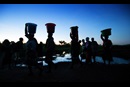 Women carry water as the sun rises at Njenjete village near Madisi, Malawi. Photo by Mike DuBose, UM News.
