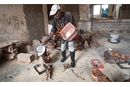 Francisco Julio Alfredo feeds chickens at the Quéssua Mission farm near Malanje, Angola. Photo by Mike DuBose, UM News.