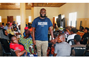 Sam Yav (standing) meets with a group that seeks to understand how climate change impacts their lives and what they can do about it. (Photo: Courtesy of Sam Yav)