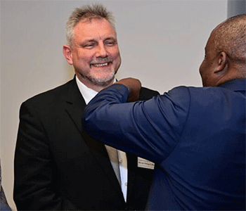 Bishop Mande Muyombo places the bishop's pin on the Rev. Werner Philipp's lapel after he was elected a United Methodist bishop at the Germany Central Conference on Feb. 13 in Würzburg, Germany. Photo by Klaus Ulrich Ruof, EmK Public Relations.