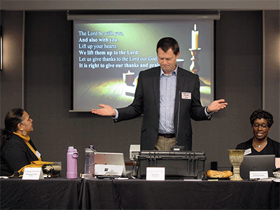 The Rev. Andy Call, chair of the General Conference commission, helps lead Holy Communion during opening worship. Sitting beside Call are Monalisa Tui'tahi (left), the commission’s vice chair, and the Rev. Aleze M. Fulbright (right), the new General Conference secretary.