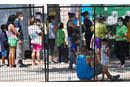 Migrants who have crossed into the U.S. from Mexico gather in Anzalduas Park in Mission, Texas. (Photo: Mike DuBose)