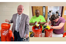 Jim Cox, UMCOR’s Executive Director, holds a finished disaster kit while other volunteers prepare a disaster kit. Courtesy photo.