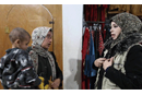 ANERA staff member assists a woman looking for winter clothes and a coat for her son. (Photo: Courtesy of ANERA)